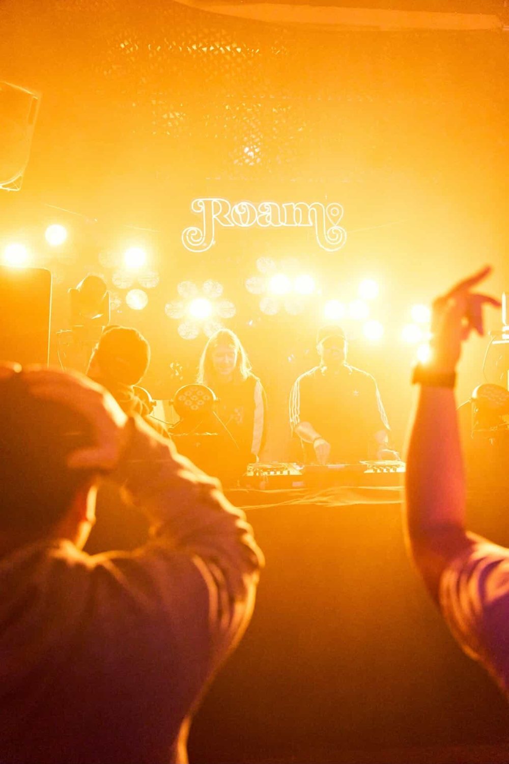 Hands up in golden light at Roam, Seattle