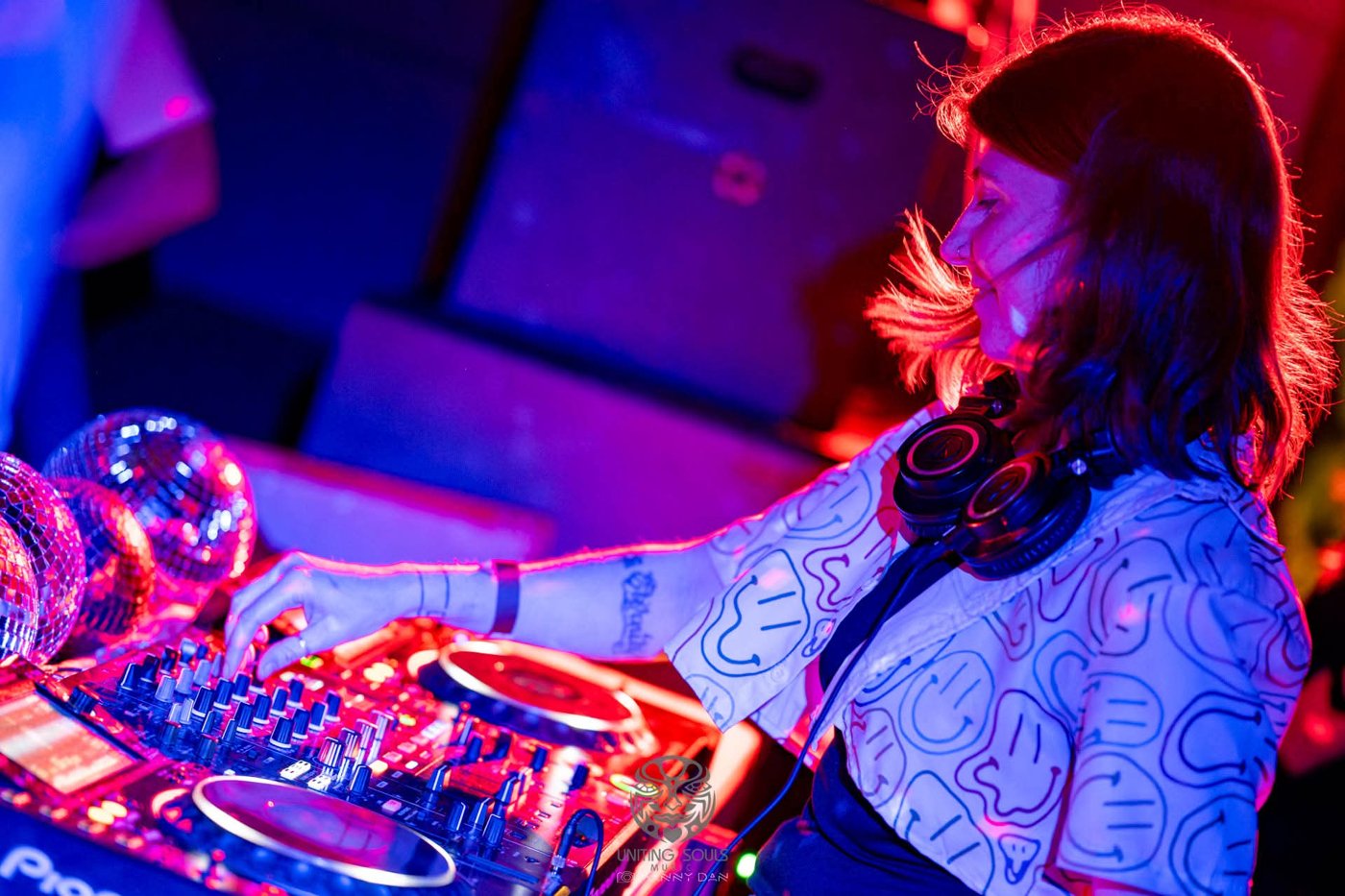AshWave mixing on Pioneer decks under purple and blue club lights